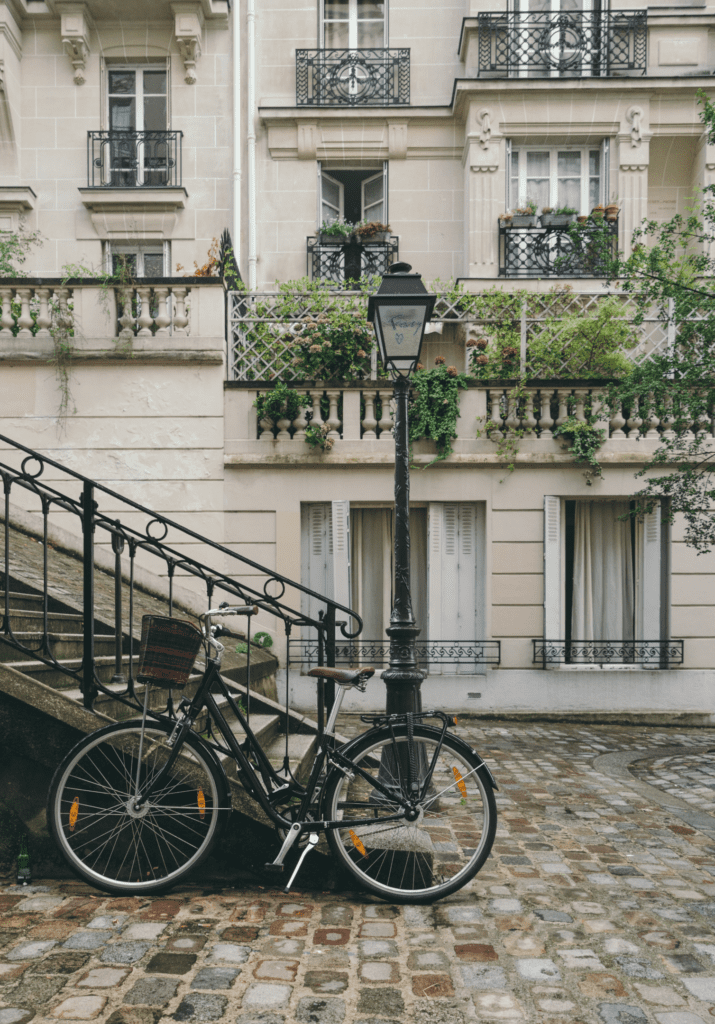 Bicicleta apoiada em escada, em ambiente urbano. Foto de JOHN TOWNER na Unsplash.