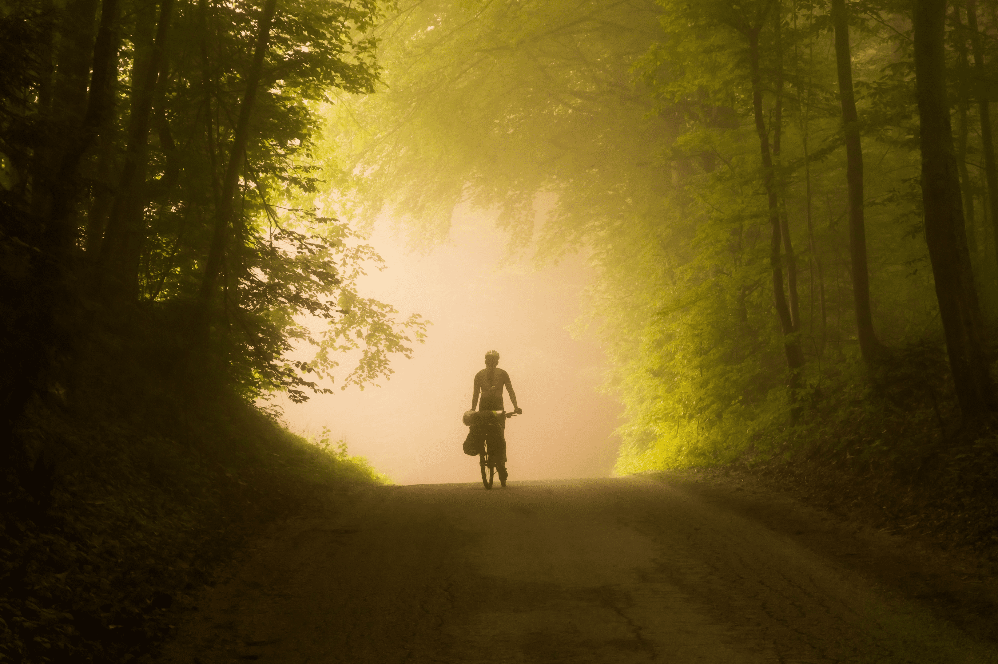 Ciclista pedalando em estrada de terra. Foto de Bogdan R. Anton, Pexels.