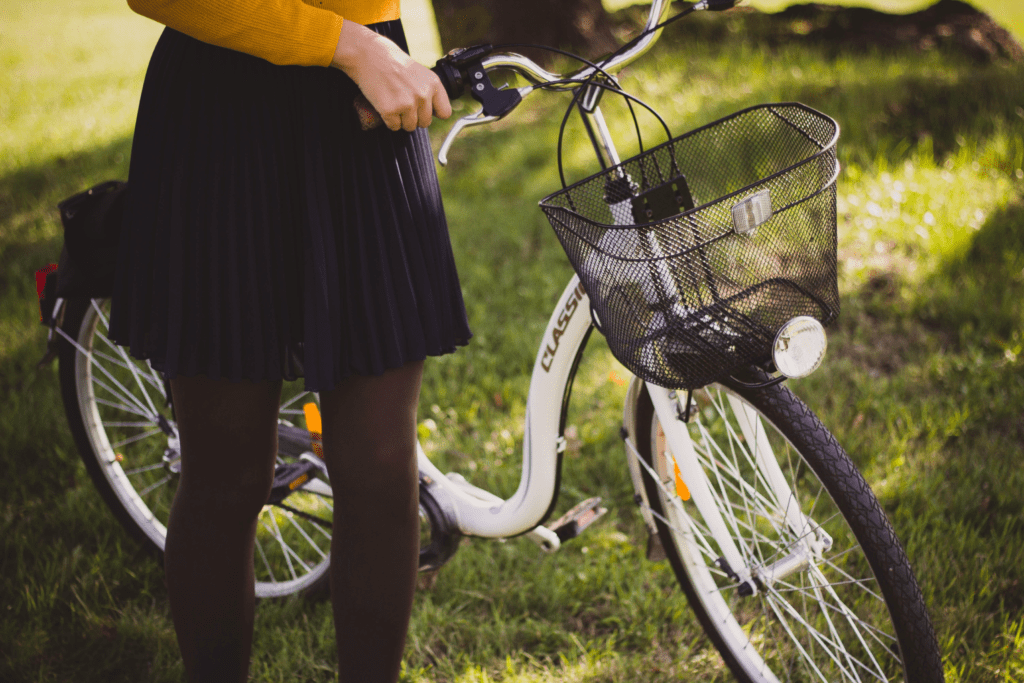 Mulher com sua bicicleta. Foto de Valeria Boltneva, Pexels.