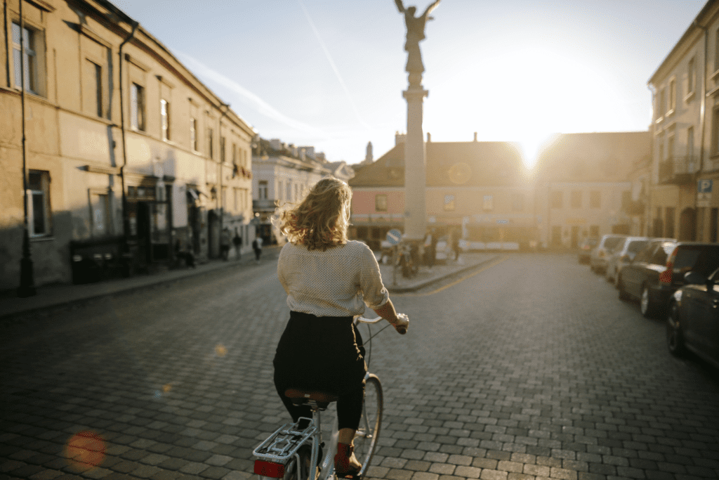 Mulher pedalando na cidade. Foto de Daria Obymaha, Pexels.