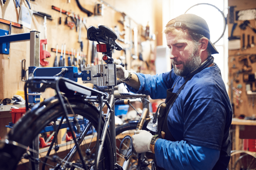 Foto: iSotck. Profissional bike fitter realizando os ajustes na bicicleta.